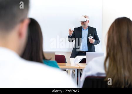 A man in a suit wearing a VR headset is teaching a class. Stock Photo