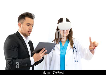 Doctor and patient discussing something while wearing virtual reality glasses. Healthcare and medical concept. Stock Photo