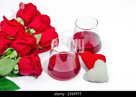 The concept of a romantic date. Two glasses of wine, handmade hearts, a bouquet of red roses. Trendy hard light, dark shadow, white background, flat l Stock Photo