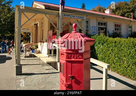 Arrowtown, Otago, South Island, New Zealand - Red hexagonal Penfold pillar box outside post office of the historic gold mining town Stock Photo