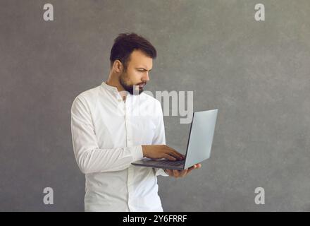 Thoughtful focused smart male programmer or employee working on deadline project. Stock Photo