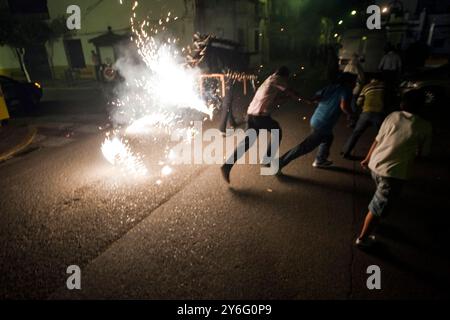 Villagers enjoy the exciting Toro de Fuego festival in Aznalcazar as fireworks explode around them, creating a vibrant atmosphere. Stock Photo