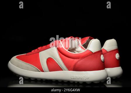 Pair of red Camper shoes vintage trainers and casual fabric urban Spanish shoes on black Stock Photo