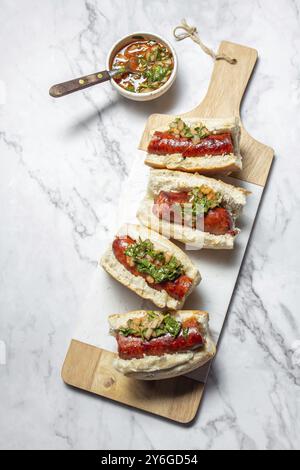 Food, Chilean and Argentinian food. Traditional choripan with spicy pebre, chorizo sandwich with chorizo sausages and bread Stock Photo