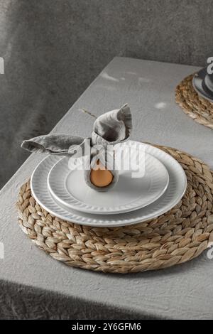Food, Food, Festive Easter table setting. Funny Easter bunny made of egg and linen napkin on plate. Gray background Stock Photo