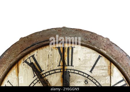 Old vintage and retro analogue clock displaying five minutes to twelve. Worn-out and grunge style with wooden background. Front view Stock Photo