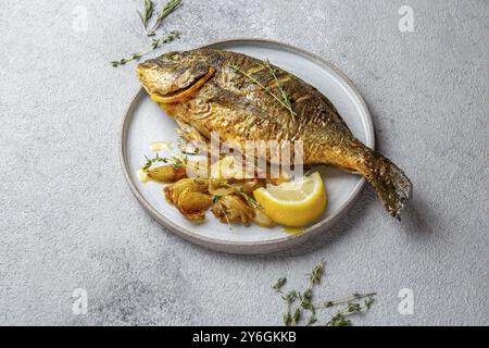 Food, Grilled sea bream or dorada on gray plate. Gray background Stock Photo