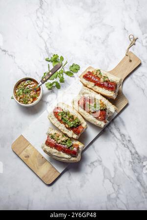 Food, Chilean and Argentinian food. Traditional choripan with spicy pebre, chorizo sandwich with chorizo sausages and bread Stock Photo