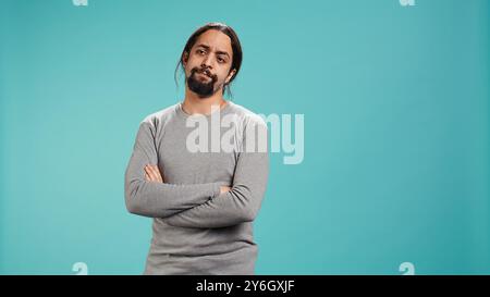 Man shakes head in disbelief, showing lack of satisfaction, isolated over studio background. Disappointed Arab person disagreeing with another person, studio backdrop, camera B Stock Photo