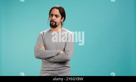 Man shakes head, showing negative emotion, showing lack of satisfaction, isolated over studio background. Irked person disagreeing with friend during conversation, studio backdrop, camera B Stock Photo