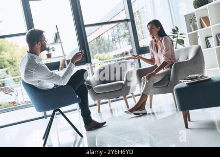 First you should recognize the problem. Young frustrated woman speaking and gesturing while sitting on the therapy session with psychologist Stock Photo