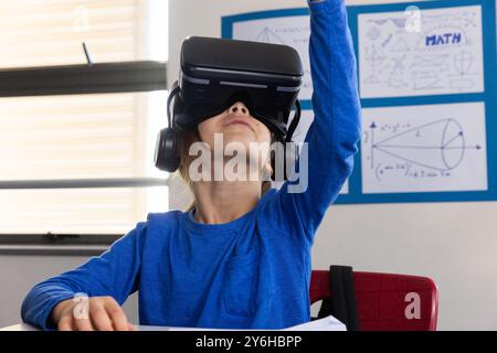 In school, boy using VR headset for interactive learning in classroom Stock Photo
