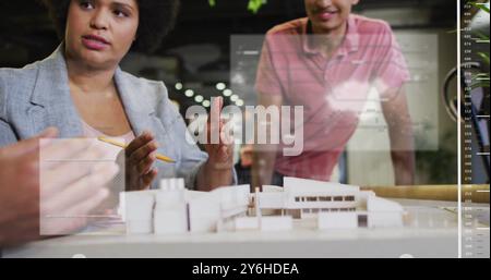 Image of data processing and world map over diverse business people discussing work in office Stock Photo