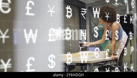 Image of currency symbols over diverse business people discussing work in office Stock Photo