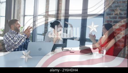 Celebrating business success, diverse team in office over American flag image Stock Photo