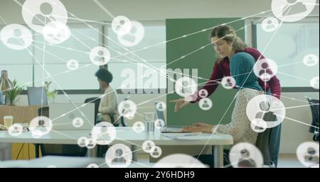 Image of network of connections with people icons over diverse business people in office Stock Photo