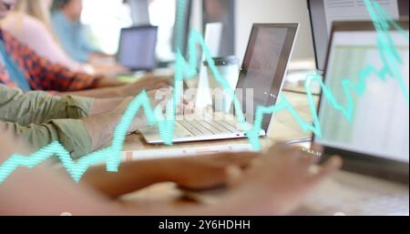 Image of data processing and diagrams over diverse business people using laptops in office Stock Photo
