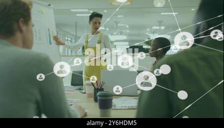 Image of network of connections with people icons over diverse business people in office Stock Photo