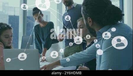 Image of network of connections with people icons over diverse business people in office Stock Photo