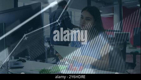 Image of financial data processing over caucasian businesswoman in office Stock Photo