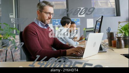 Image of data processing over caucasian businessman using laptop in office Stock Photo