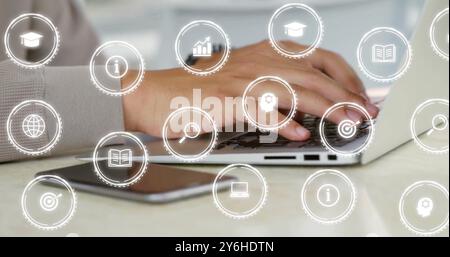 Image of icons over caucasian businessman using laptop in office Stock Photo