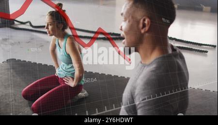 Red line graph image over people exercising in gym Stock Photo