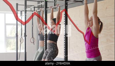 Graph image over women doing pull-ups in gym Stock Photo