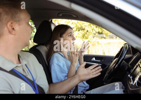 Driving school. Emotional woman having driving lesson Stock Photo