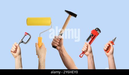Hands of people with different tools on light blue background Stock Photo