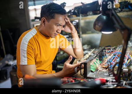 Portrait of a serious technician focusing on hardware repair in the workplace Stock Photo