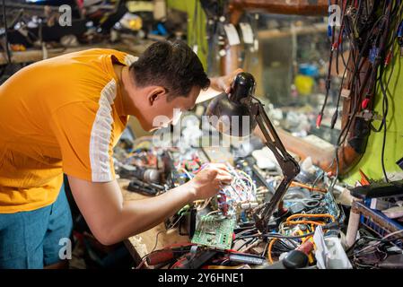 serious technician working with lighting fixes electronic items on the workbench Stock Photo