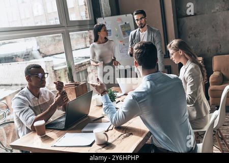 Developing new strategy. Top view of two young colleagues conducting a business presentation while working in the creative office Stock Photo