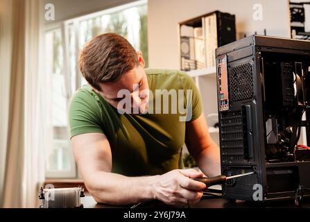 Man assembles a computer system unit at home Stock Photo