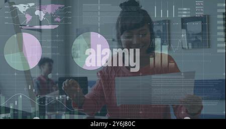 Image of financial data processing over caucasian businesswoman in office Stock Photo