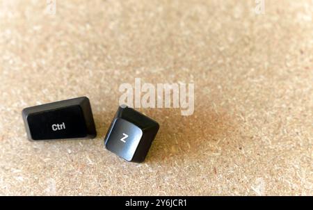 Two black keys are laying on a wooden surface. One of the keys is labeled CTRL and the other is labeled Z. Undo concept Stock Photo
