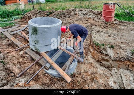 Concrete rings placed on top of each other using roller bed system when installing septic tank. Stock Photo