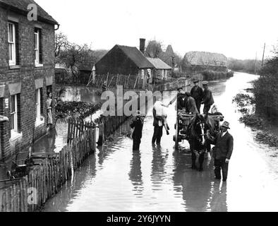 Widespread havoc caused by floods after heavy rain as the level of the River Medway burst its banks and cut off villages. Here marooned villagers are carried from their houses to a horse and cart, the only means of transport possible at Fowle Hall, Paddock Wood, Kent 19 November 1935  ©TopFoto Stock Photo