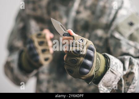 The man wearing tactical gloves using the mini knife. Stock Photo