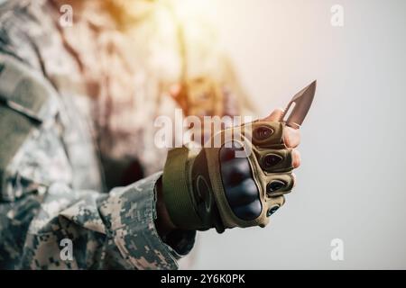 The man wearing tactical gloves using the mini knife. Stock Photo