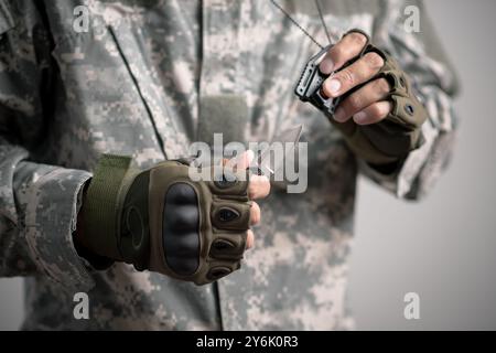 The man wearing tactical gloves using the mini knife. Stock Photo