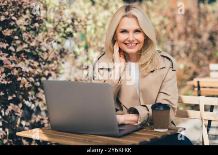 Photo of lovely adorable woman sitting on cafe terrace working remotely during weekend vacation outdoors morning coffee Stock Photo