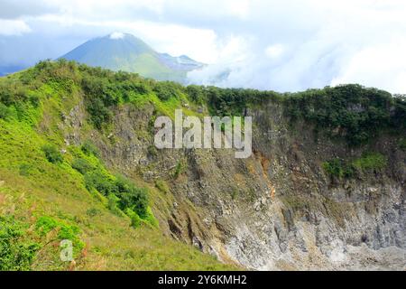 Crater wall at the top of Mount Mahawu with Mount Lokon in the background, Tomohon, North Sulawesi. Stock Photo