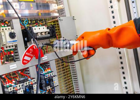 Electrician testing an electrical panel Stock Photo