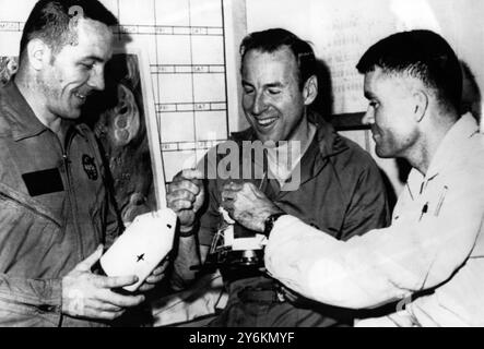 An electrical problem aboard the Apollo 13 yesterday , ruled out its moon landing attempt and  use an emergency system to return to earth .  Astronauts James Lovell (centre) . Fred Haise (right) and Jack Swigert , shown in picture taken on 9th April will crowd into the two-man lander , swing around the back side of the moon , then fire the lander's descent engines to blast into a homeward route.  Mission Control maintains that the astronauts were in no immediate danger despite the serious electrical fialure and an oxygen leak in the command module  14th April 1970 Stock Photo