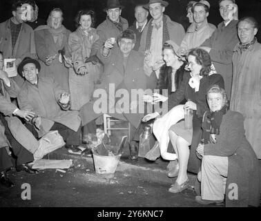 Royal Wedding. Jimmy Wright, a canadian who has travelled 7000 miles to see the Royal Wedding, seen wearing a beaver cap seen keeping warm round a fire in the Mall, at 2 o'clock this morning, with other people who also braved the weather by waiting all night to get a good view of the wedding.  20 November 1947 Stock Photo