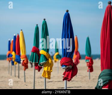 Fashionable seaside resort of Deauville, Normandy, France. The colourful umbrellas, parasols , wind breakers are located on the sandy beach. Stock Photo