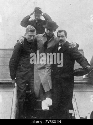 On the other side: 'Titanic' disaster survivors in New York. Carried ashore with feet crushed and frostbitten Mr Harold Bride, second wireless operator of the 'Titanic' leaving the 'Carpathia.'  4 May 1912 Stock Photo