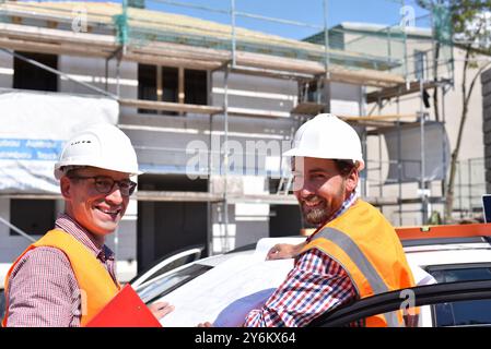 construction manager and architect on site during the construction of a house - planning and control on site - teamwork Stock Photo