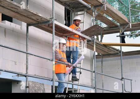 construction manager and architect on site during the construction of a house - planning and control on site - teamwork Stock Photo